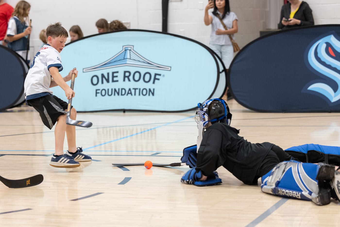 A young player shooting on a diving goalie at Grow the Game Day
