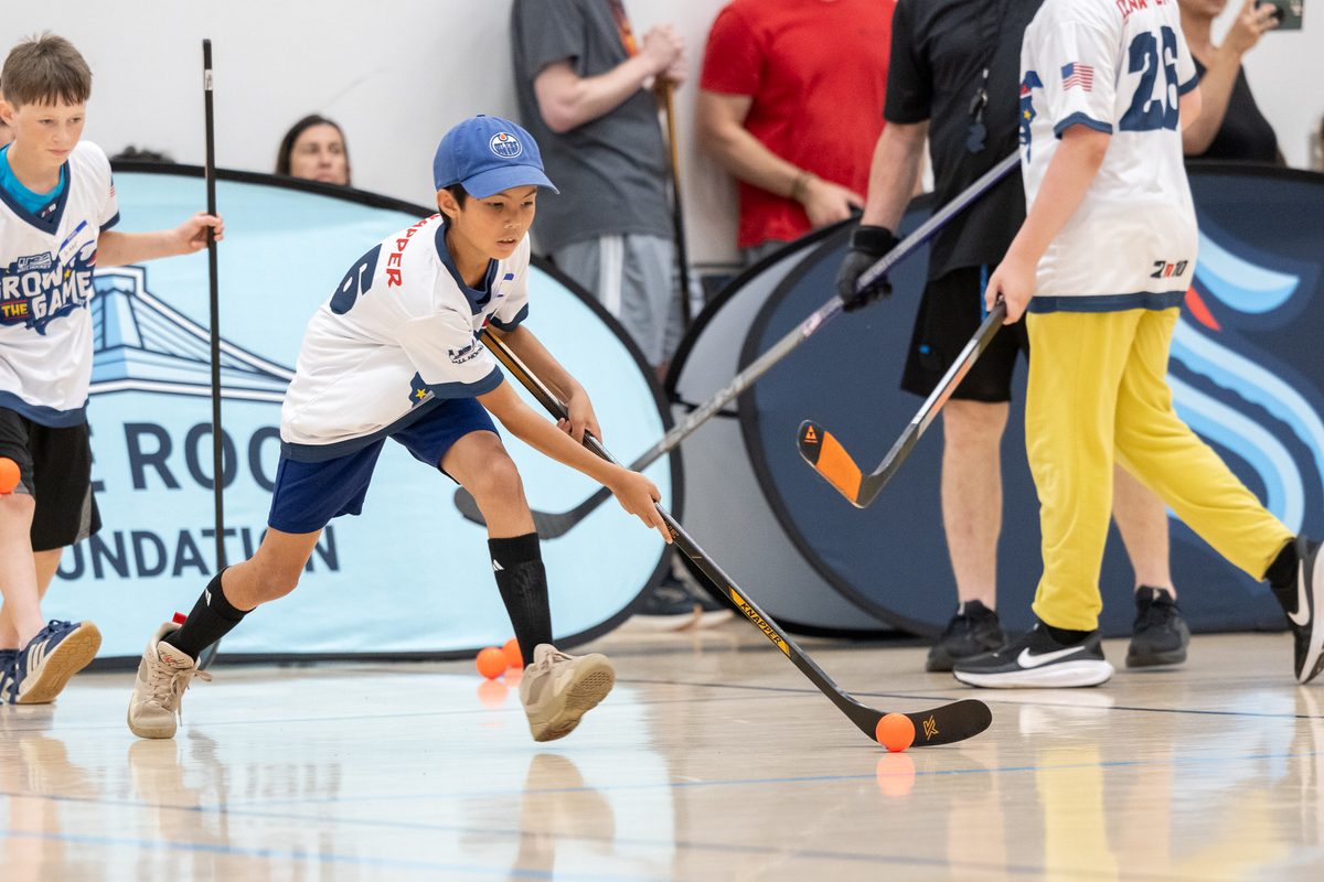 A young ball hockey player stickhandling the ball