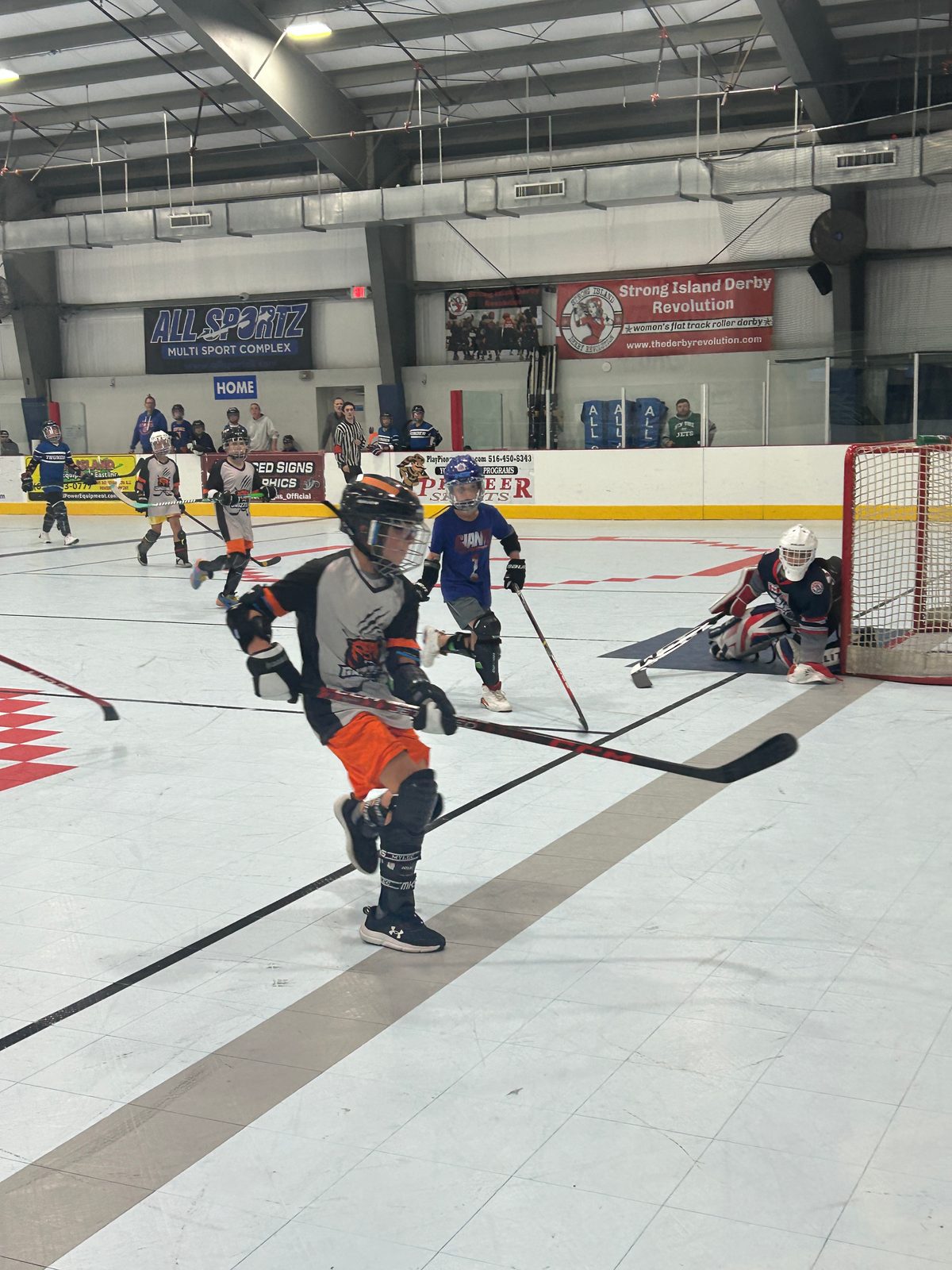 Youth ball hockey game action inside an arena