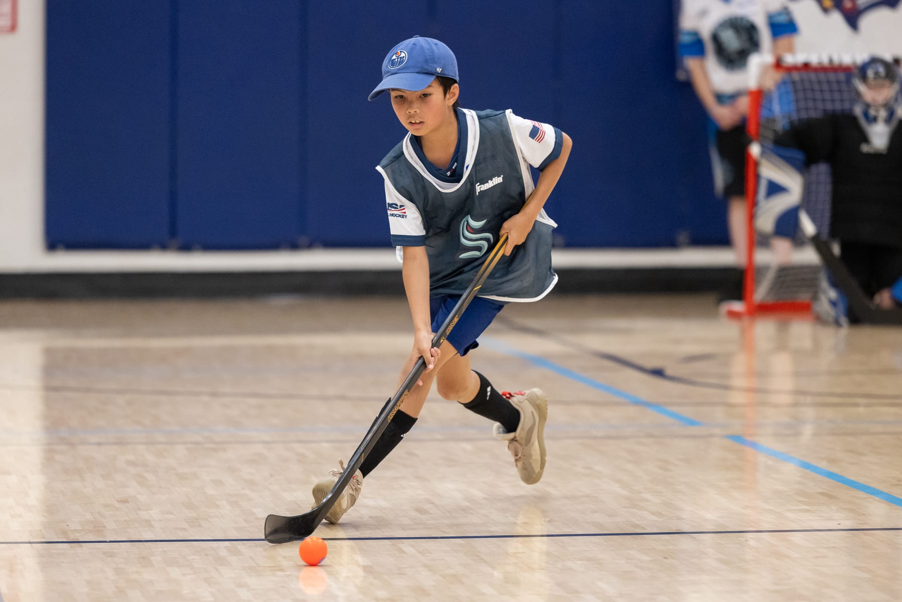 A player driving up the floor with the orange ball