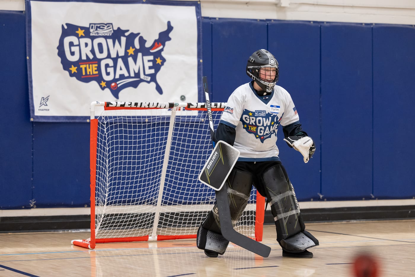 A young Emerald City Ball Hockey goalie guarding the net