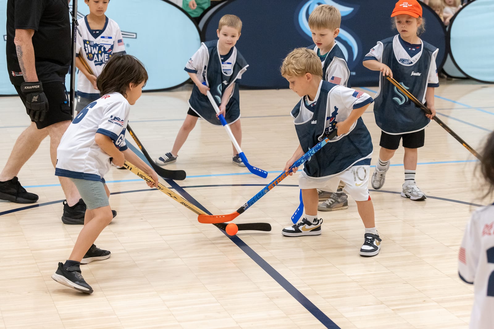 Young Emerald City Ball Hockey players battling for the ball during a game